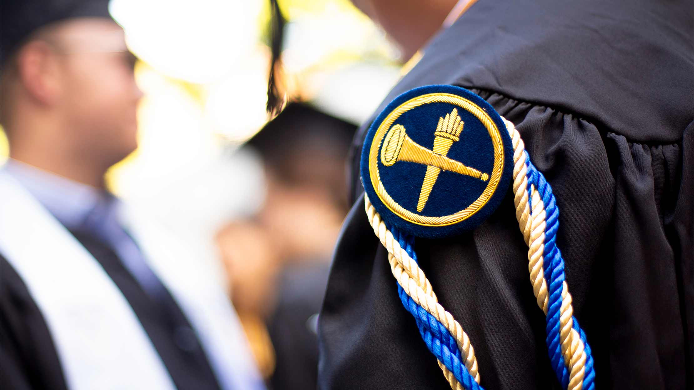 Closeup photo of an Emory patch and cord on a graduation gown
