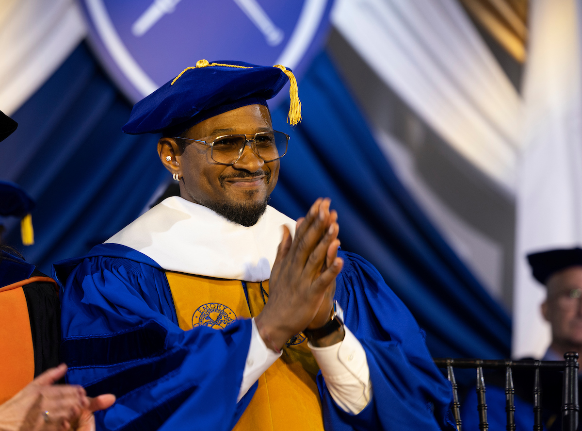 Usher Raymond IV smiling and clapping after giving his keynote address